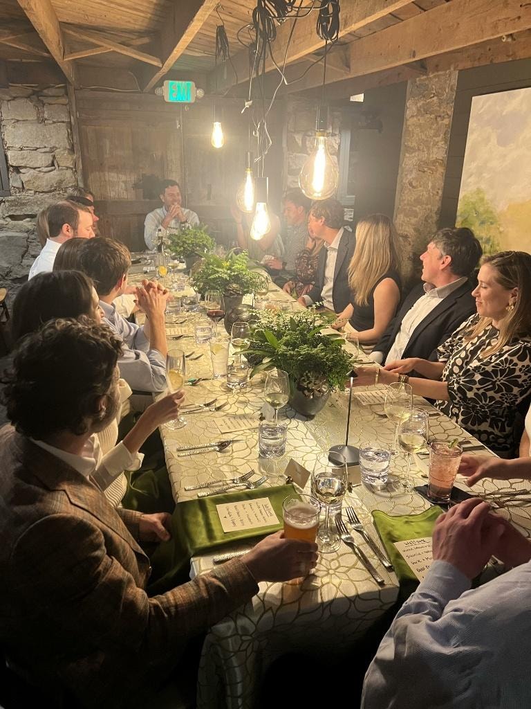 Corporate group dining together in The Saluda Inn Wine Cellar under warm Edison bulb lighting
