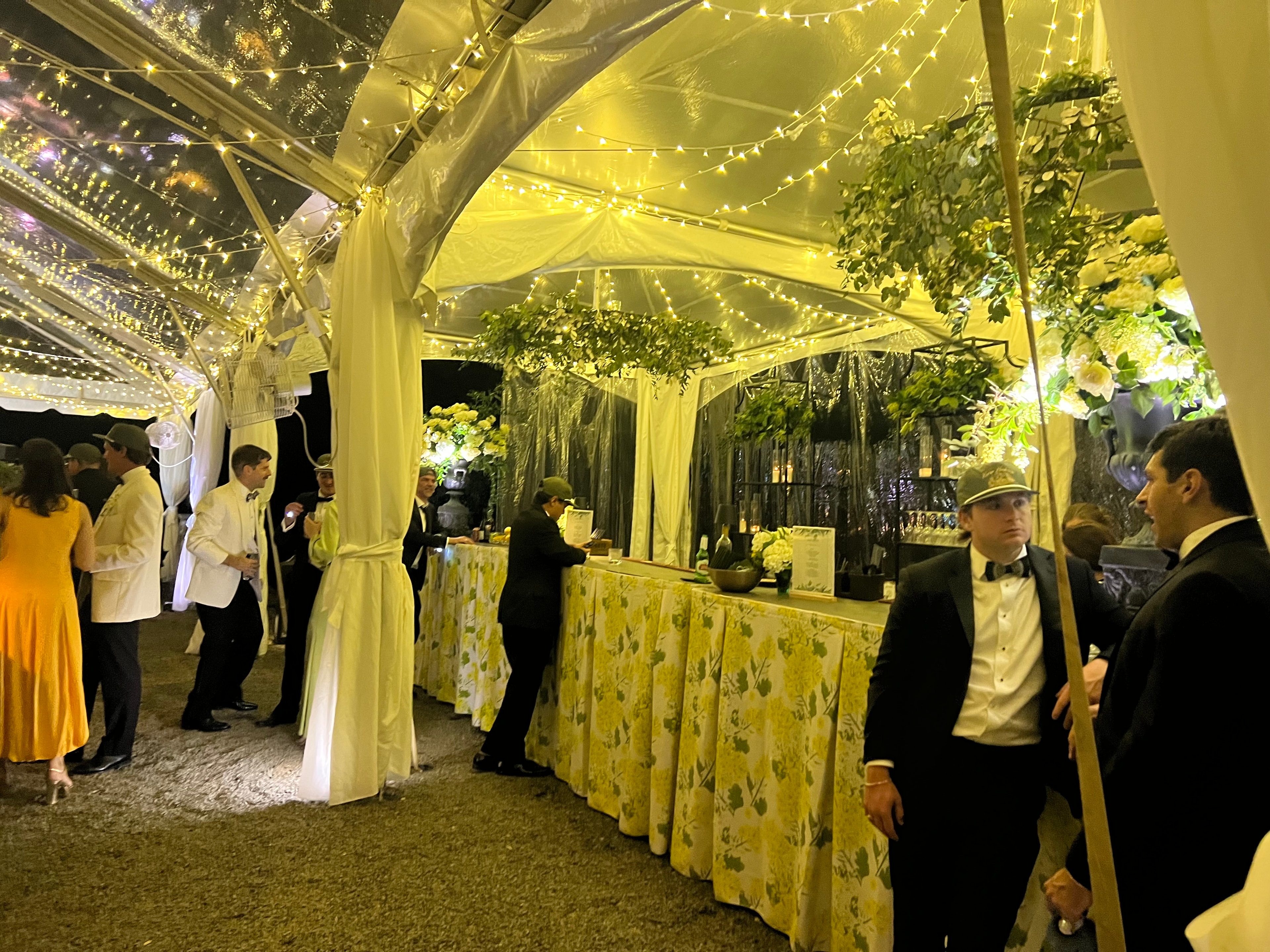 Daytime wedding setup with green linens and white hydrangeas under clear tent at The Saluda Inn
