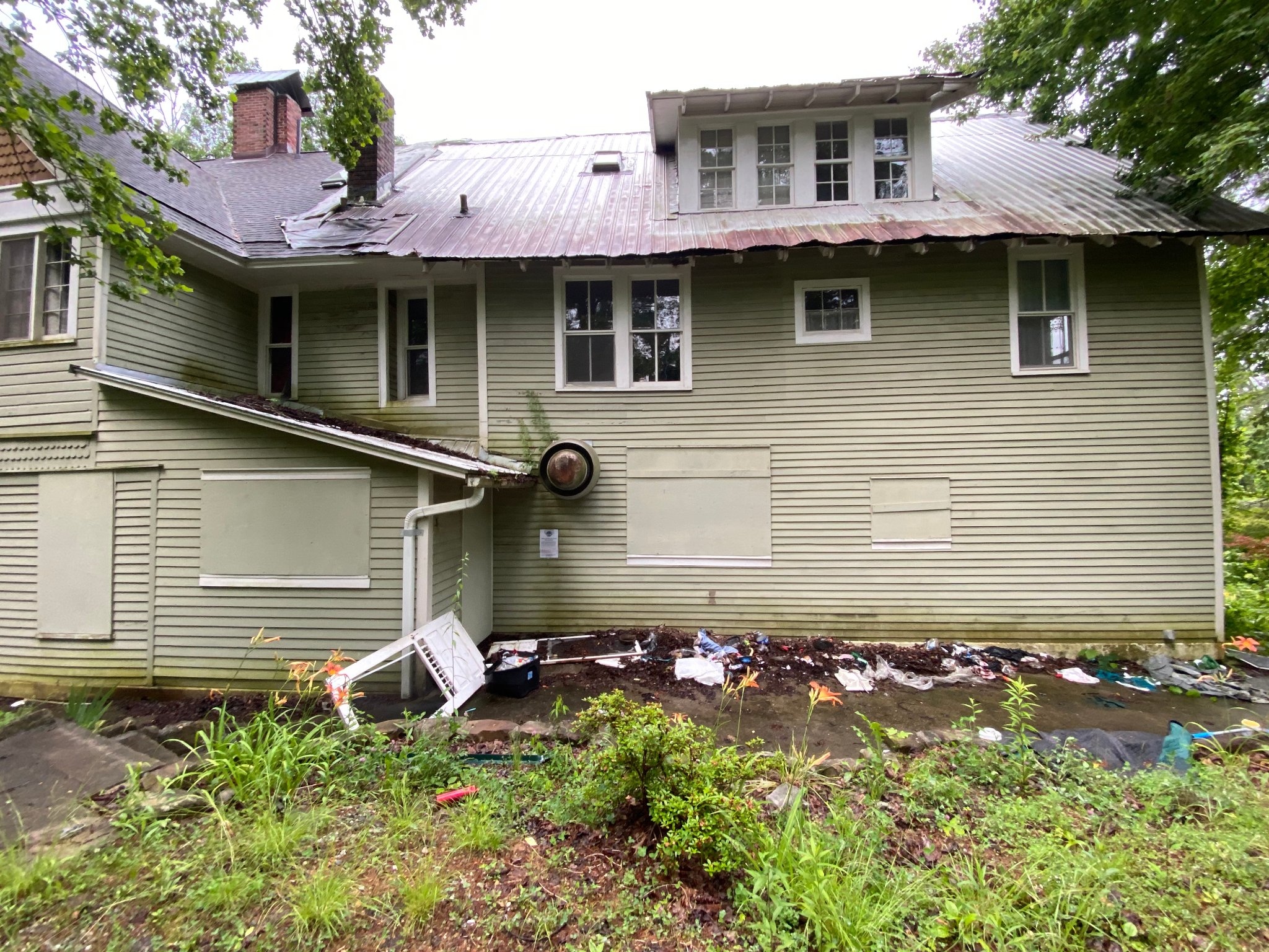 Rear exterior — boarded windows & damage
