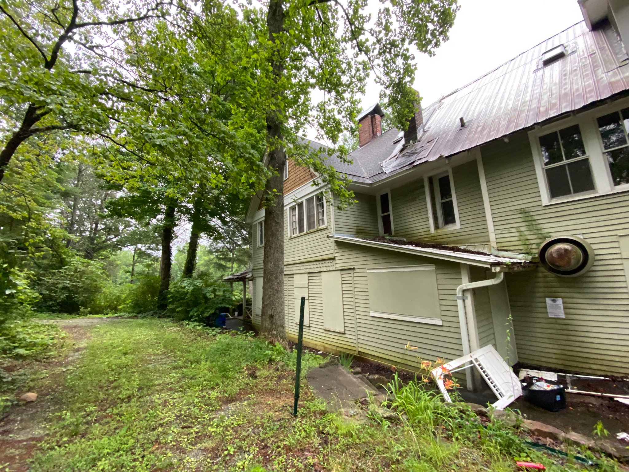 Side exterior — collapsed gutters & refuse