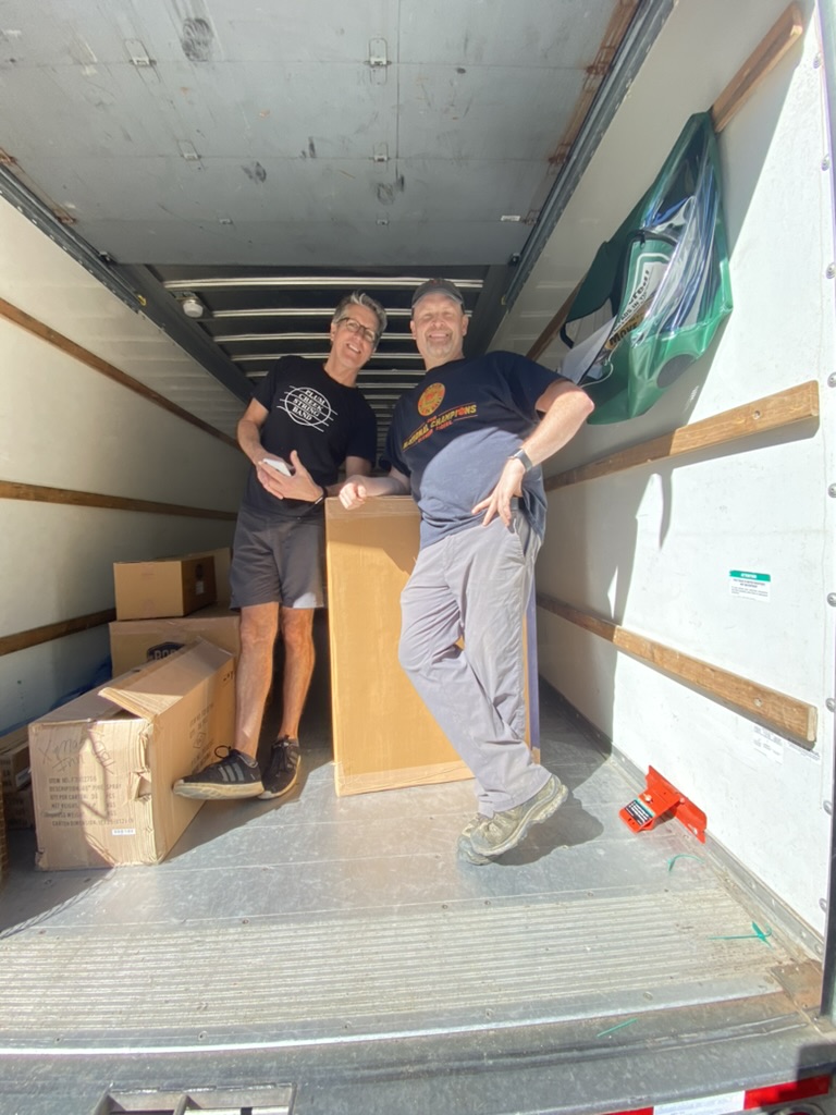 Joel & Jay — smiling in the moving truck, furniture haul for the inn