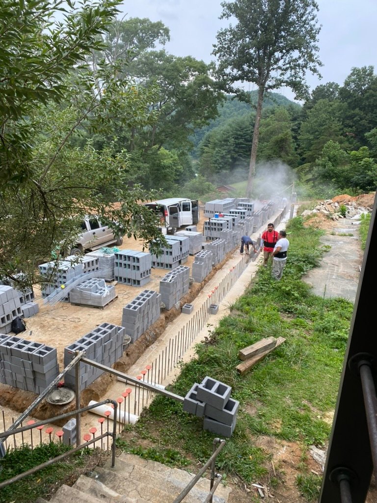 Block delivery day — hundreds of CMU blocks staged for the terrace walls