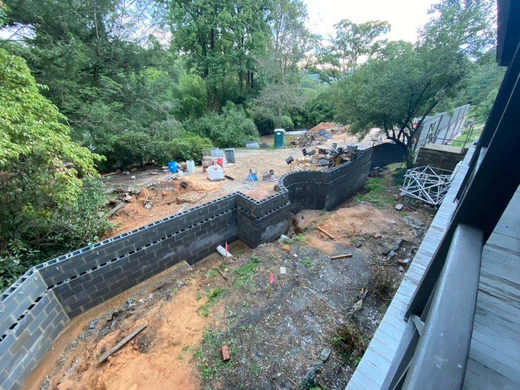 Aerial view — terrace walls taking shape, inn in the background