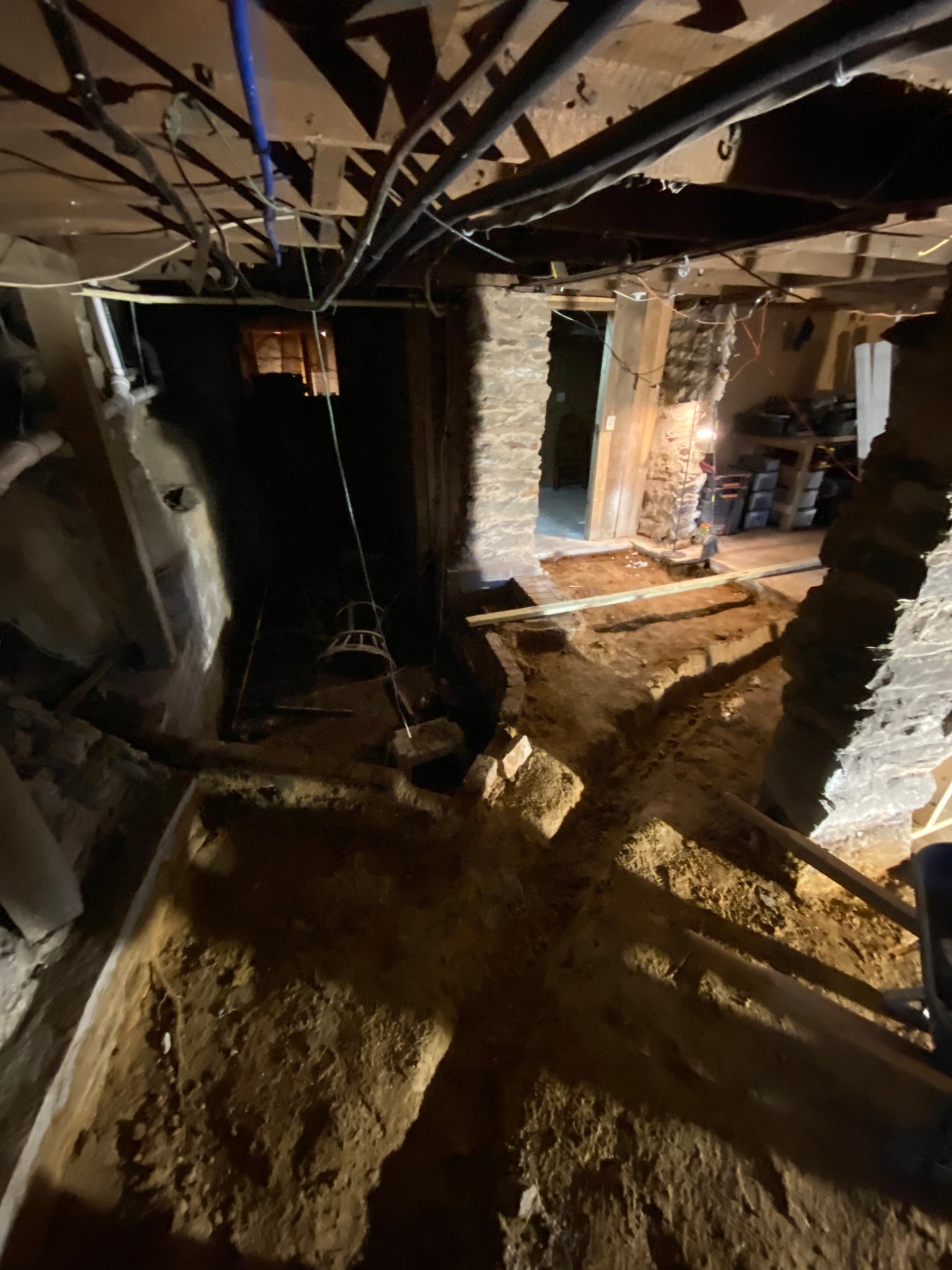Wine Cellar rough-in — stone walls & plumbing taking shape